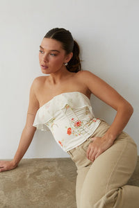 A lady in a floral corset top and cute pants from American Threads, perfect for summer vacation outfits.