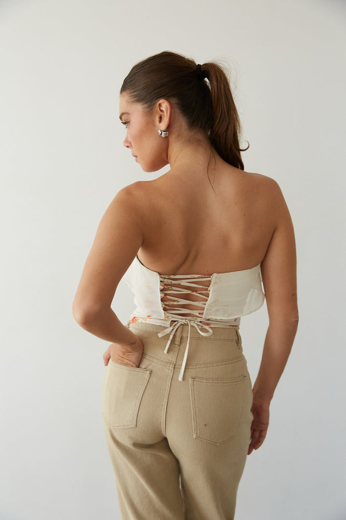 Back view of a woman in a lace-up corset top and cute pants from American Threads, ideal for summer outfits.