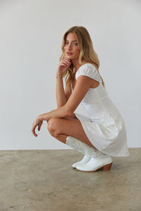 crouched view | white eyelet puff sleeve fit and flare mini dress | cottagecore white mini dress