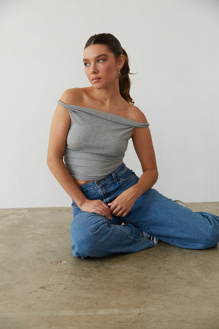 A woman in an off-shoulder cute top and trendy jeans from American Threads, perfect for casual fall outfits.