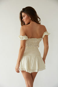 Back view of woman in a white ruffled mini skirt and crop top by American Threads, perfect cute top set.