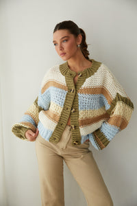 Woman in a cozy striped knit sweater and beige pants from American Threads, showcasing cute fall clothing.