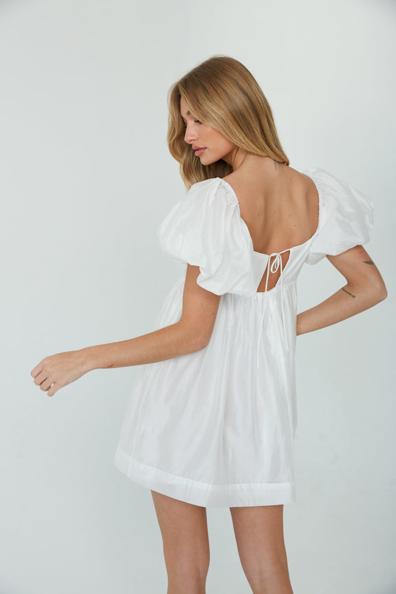 white babydoll mini dress with puff sleeves and semi open back